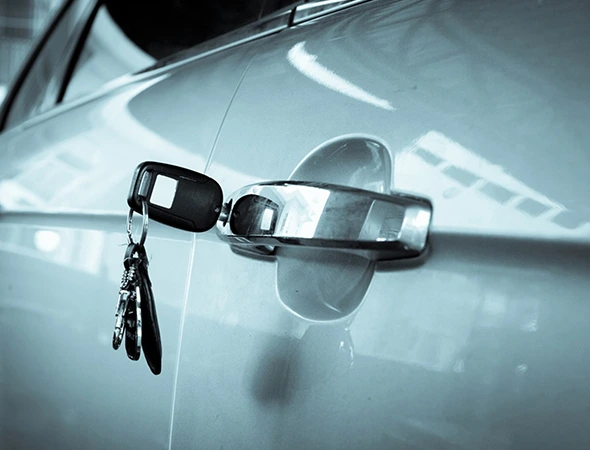 Car key inserted in a car door, representing professional key replacement service availability.