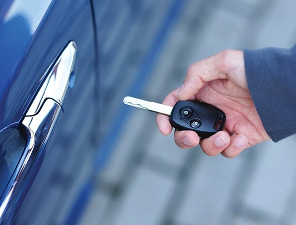 Person unlocking car with duplicate key, representing professional car key duplication service.